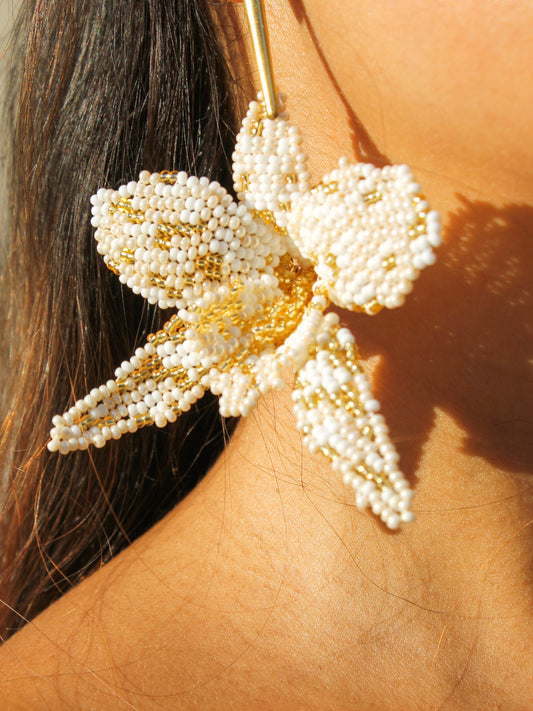 Close-up of the La Flor earring by Dearly, each petal woven bead by bead in ivory and gold