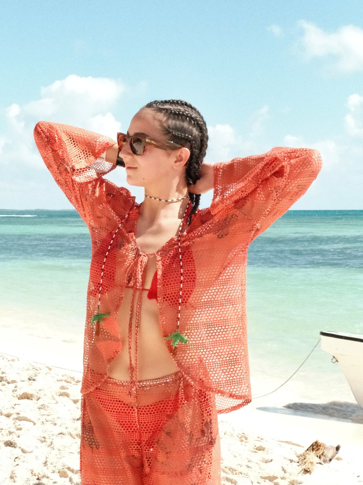 Red Isla mesh shirt by Bahama Mama worn open on a white-sand Caribbean beach