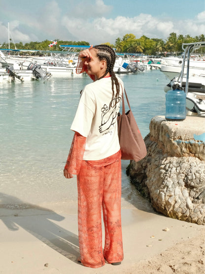 The red Isla mesh trousers worn with a plain tee at a Caribbean marina