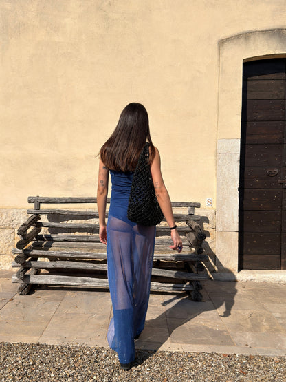 Back view of the blue Nocturna Dress by Bahama Mama, worn with a black woven bag