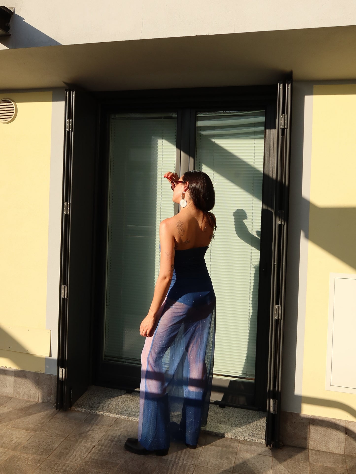 Back view of the Nocturna Dress by Bahama Mama, walking away in the sun