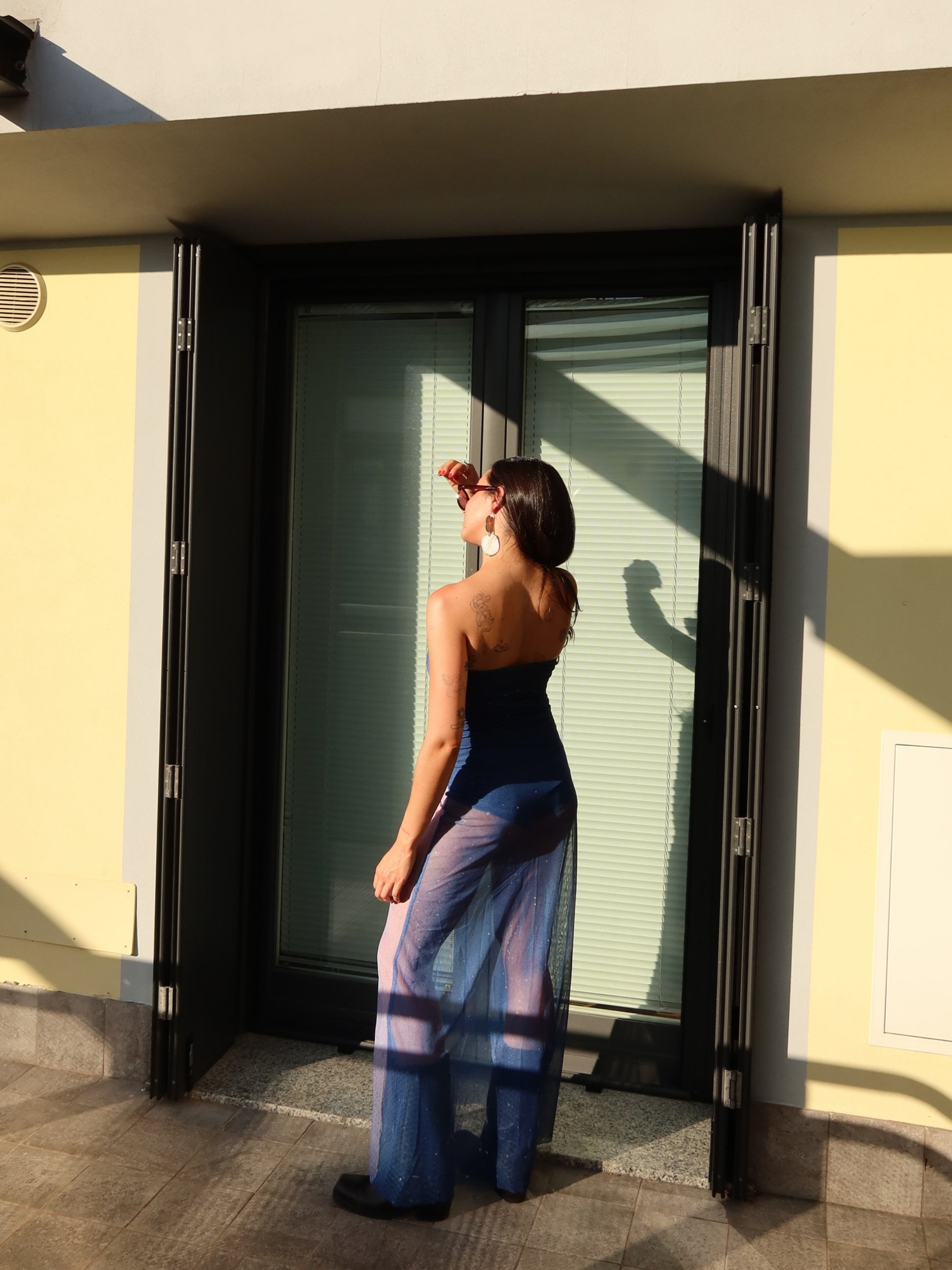 Back view of the Nocturna Dress by Bahama Mama, walking away in the sun