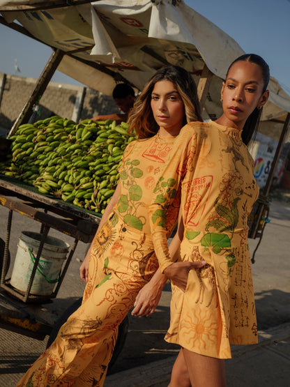 Two models in the Circe Trofo ochre printed set beside a banana stall