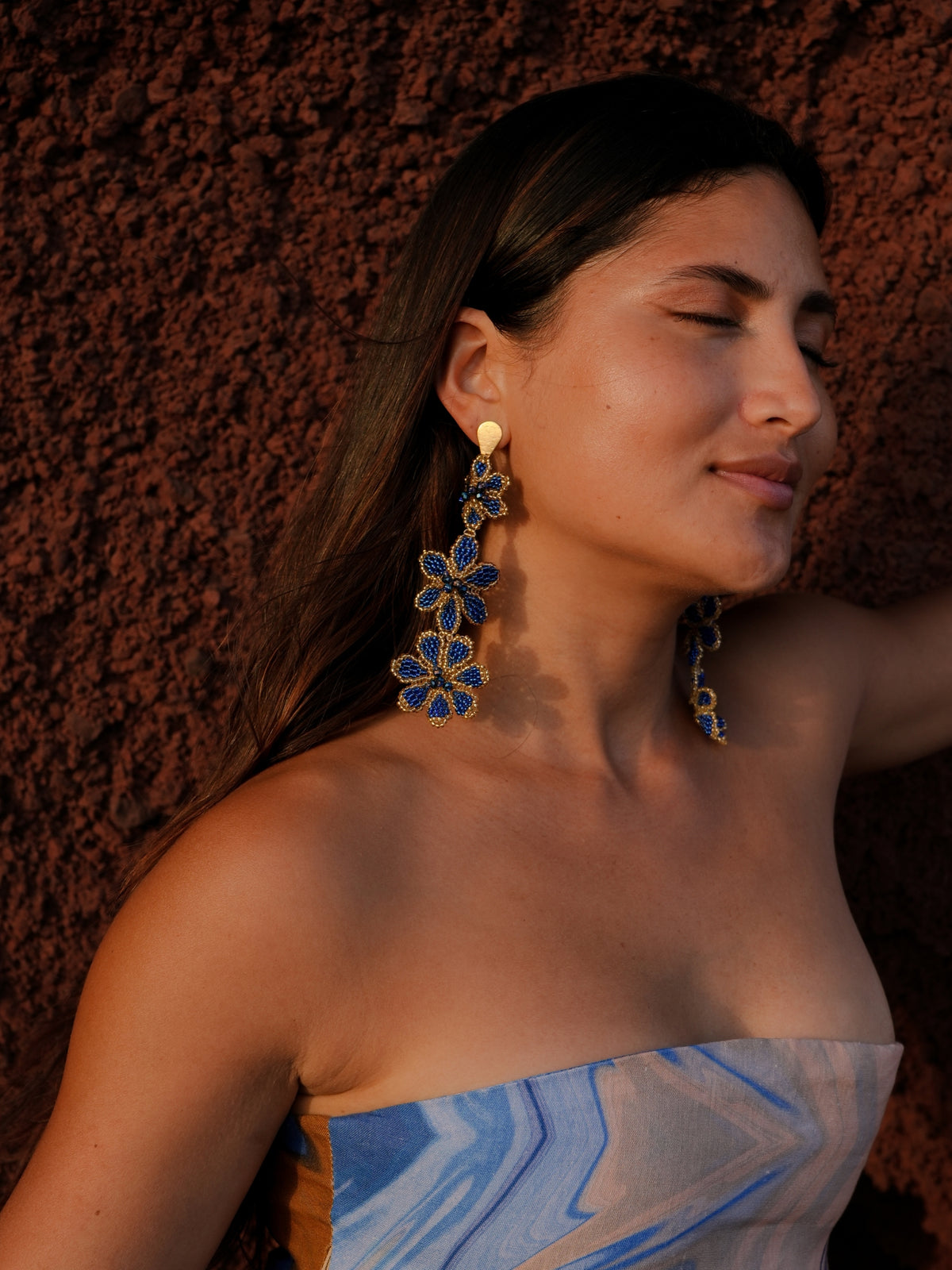 Azulita Earrings by Dearly worn against a red earth wall in warm evening light