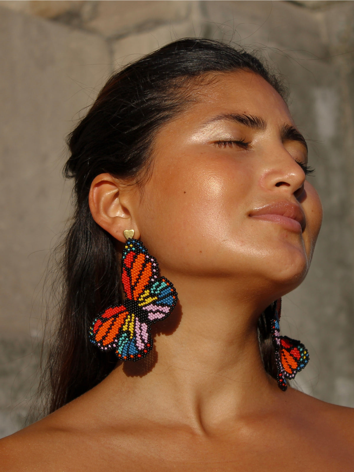 Close view of the Mariposa beaded butterfly earrings by Dearly worn on both ears
