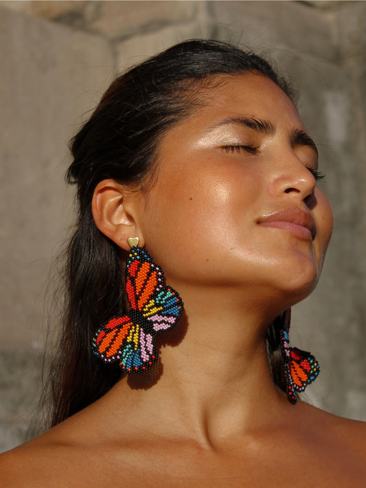 Close view of the Mariposa beaded butterfly earrings by Dearly worn on both ears