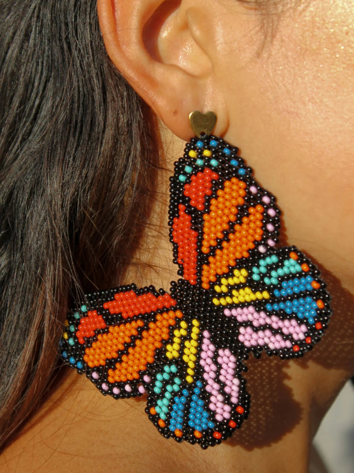 Macro detail of the Mariposa earring by Dearly: monarch wings drawn bead by bead in glass