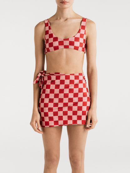 Studio view of the Saskia Red Checkers wrap skirt by Encantadore in red and pink checkerboard