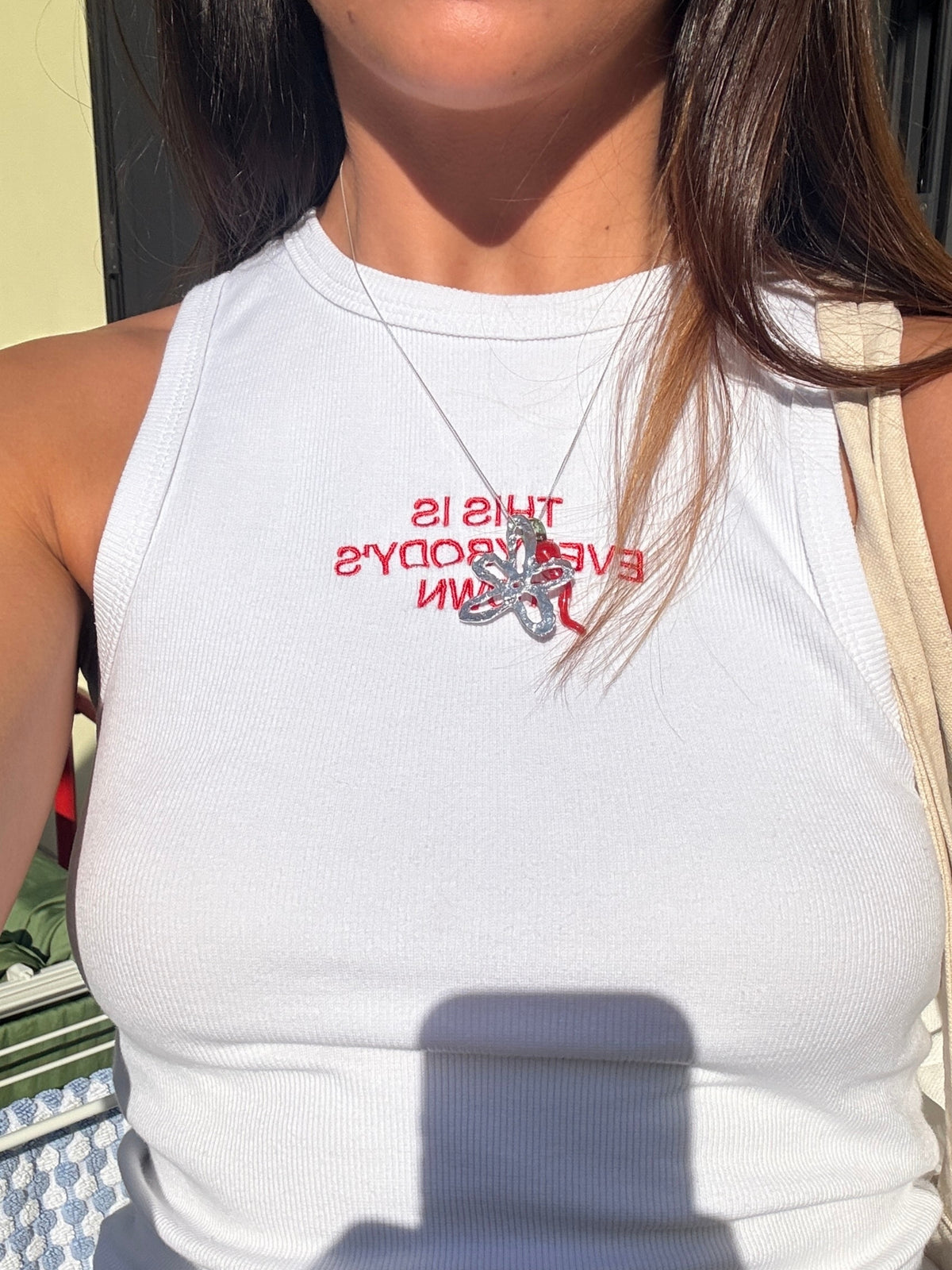 Close-up of the red slogan print on the Macondia This is Everybody's Town white tank