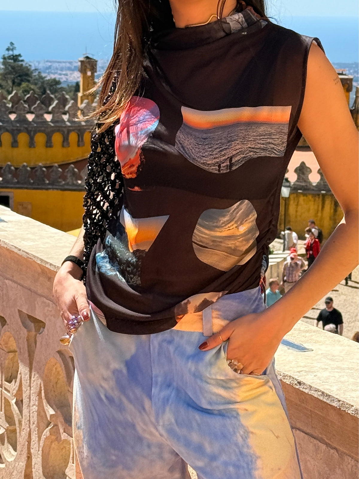 Close view of the Macondia Sunsets funnel neck top and its printed sunset motifs