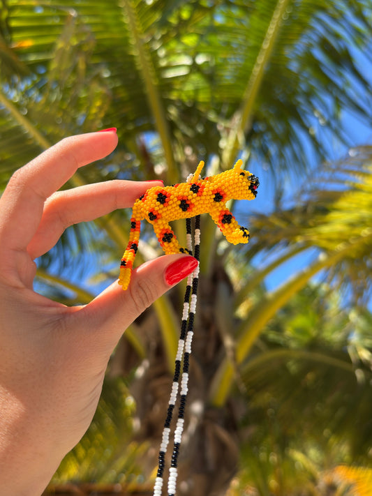 Hand holding the spotted beaded jaguar of the Jaguar Totem necklace by Pajara Pinta