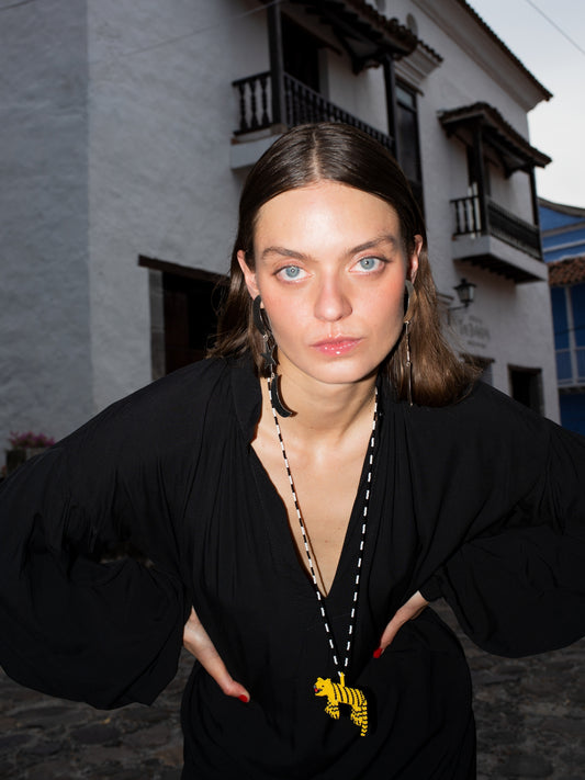 Tiger Totem necklace by Pajara Pinta worn with a black dress in a colonial street
