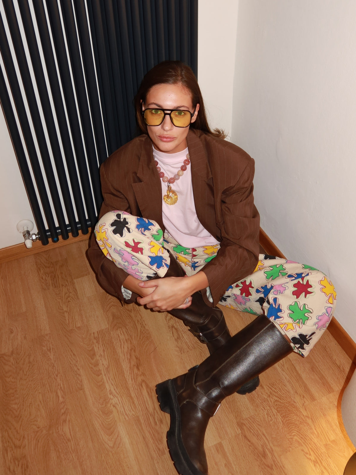 Model seated in the SIXXTA Amulet Chill Jeans with a brown blazer and boots
