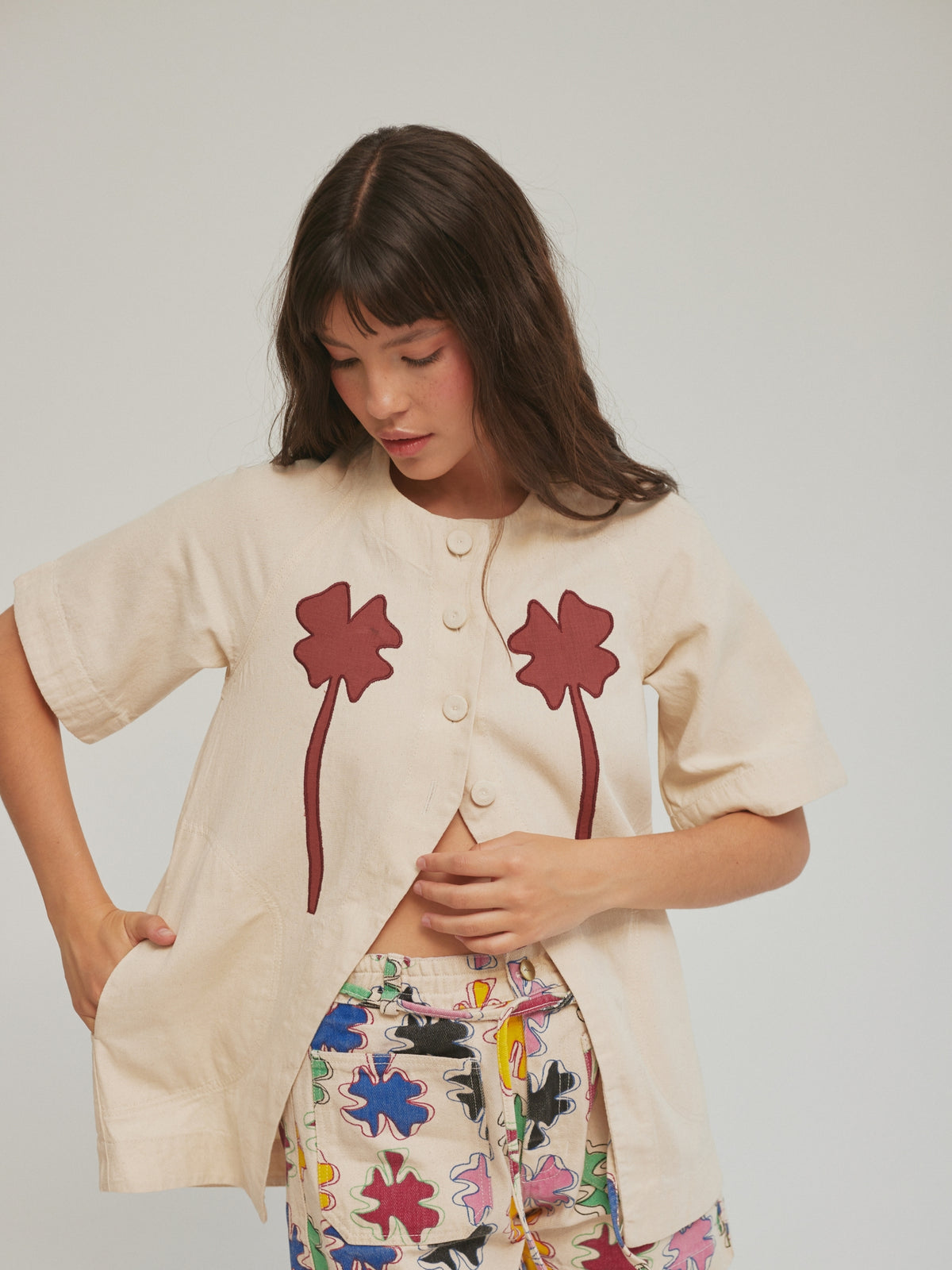 Model wearing the SIXXTA Clover Fortune Top Red with the clover-print shorts