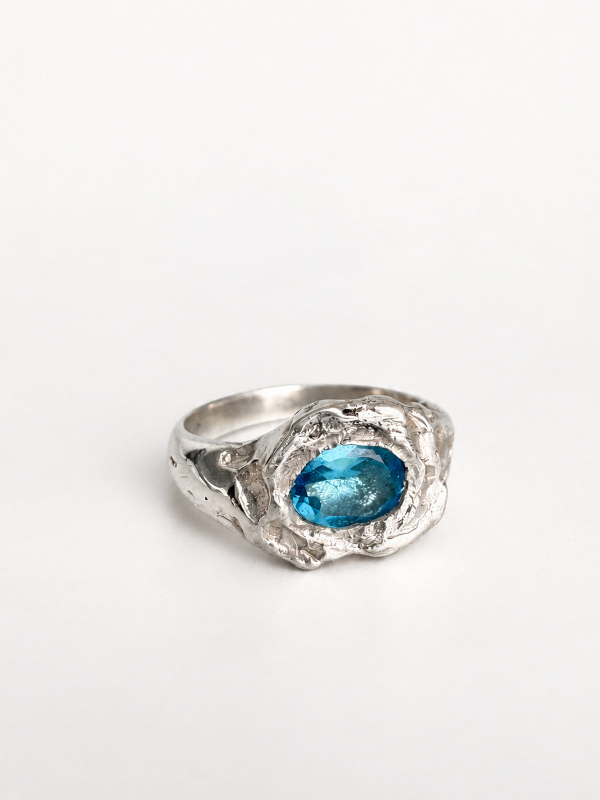 Azul Profundo Ring by STUDIO MUREA: a 950 silver ring with an oval blue topaz, on a white background