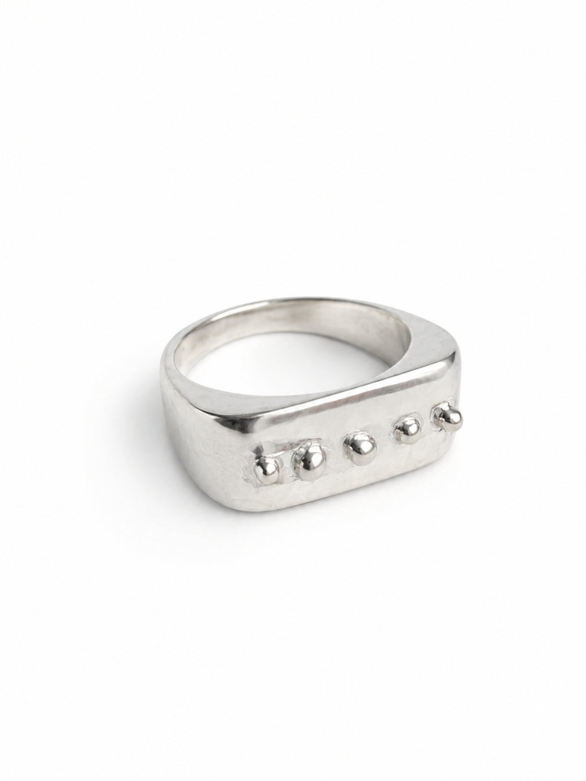 Dot Ring by STUDIO MUREA: a 950 silver ring with a flat top and five small silver dots, on a white background