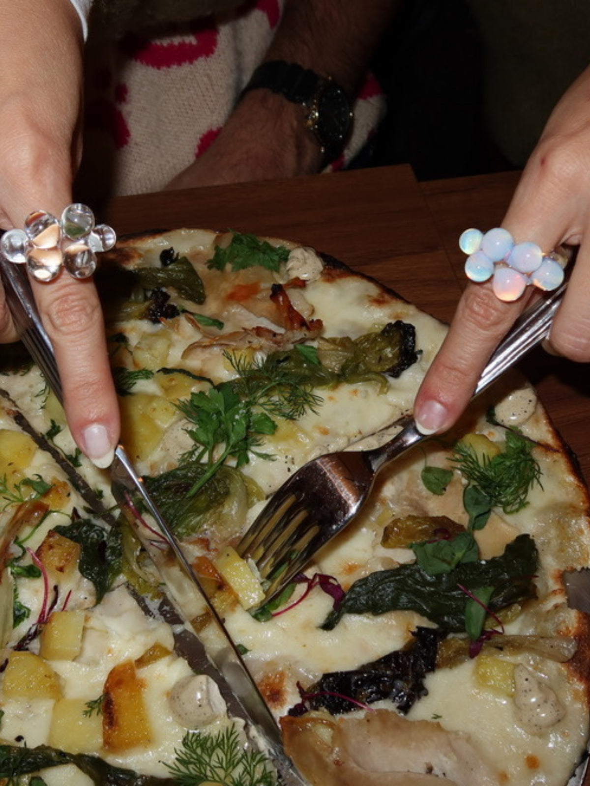 VOLD Bubbles Transparent glass rings worn at the table over a pizza