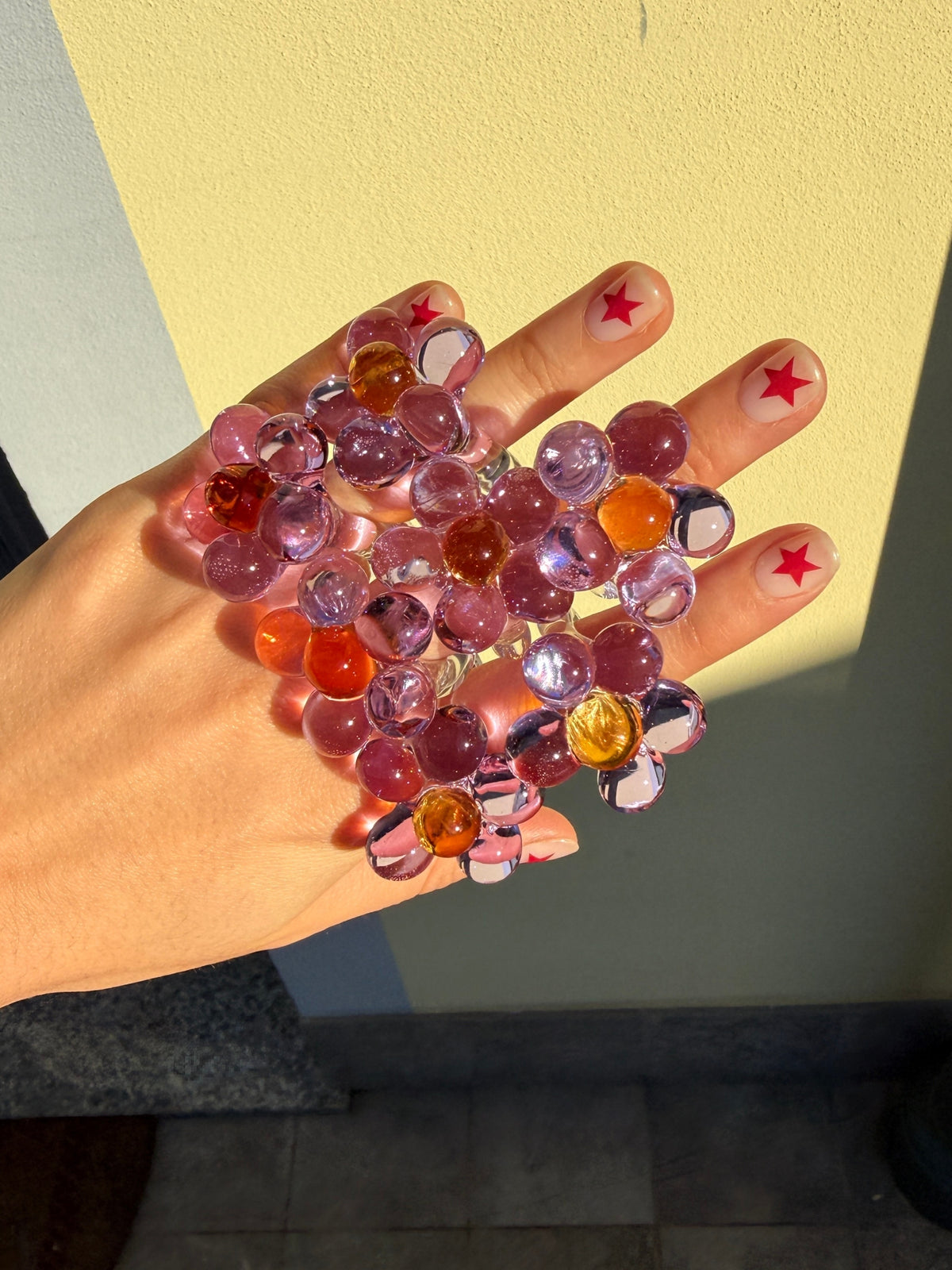 Several VOLD Florecita glass flower rings worn on one hand
