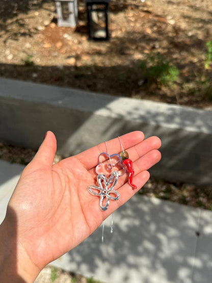 Handmade glass charms of the VOLD Mini Charm Necklace held in a palm