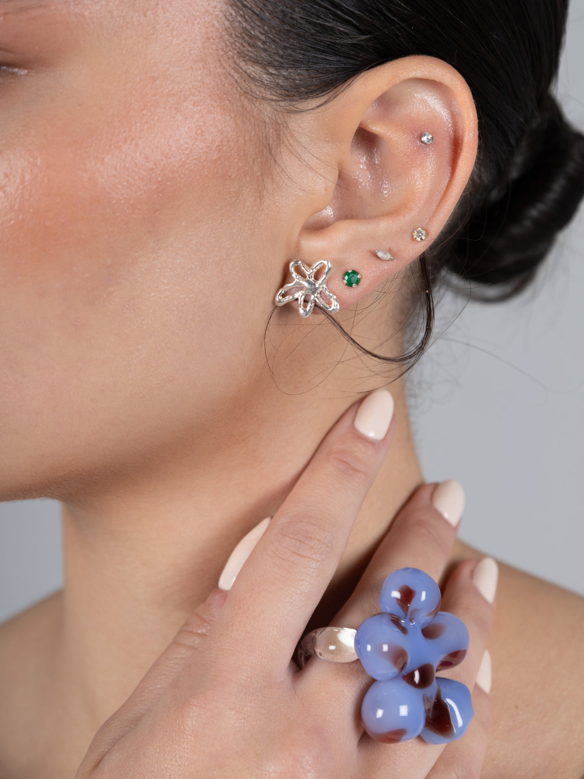 VOLD Paradise Maxi Flower glass ring worn on a hand raised to the neck