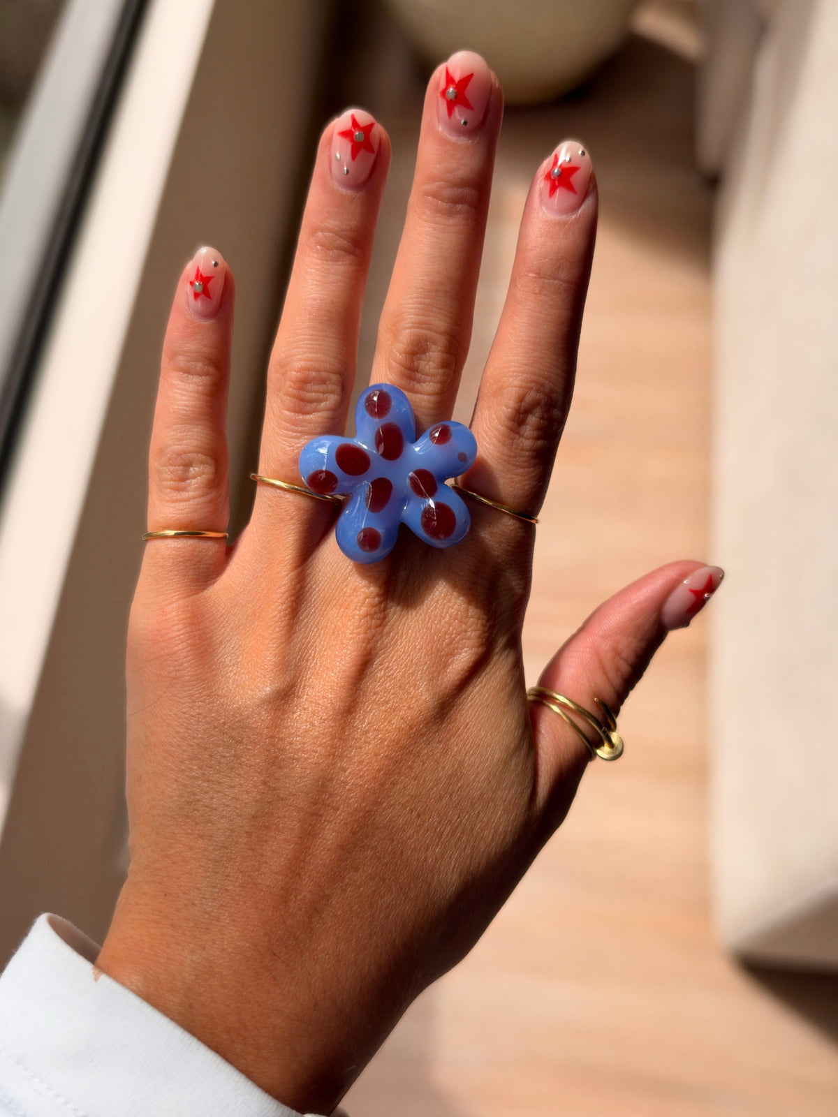 VOLD Paradise Maxi Flower ring worn with gold rings in the sunlight
